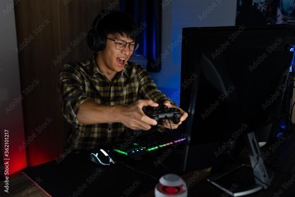 Asian man cyber sport gamer concentrated playing video games on computer eSport concept