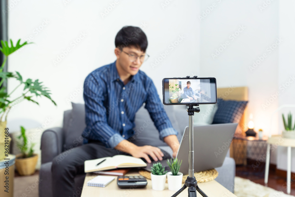 Asian blogger recording vlog video on camera review of product at home office Asian blogger recording vlog video on camera review of product at home office