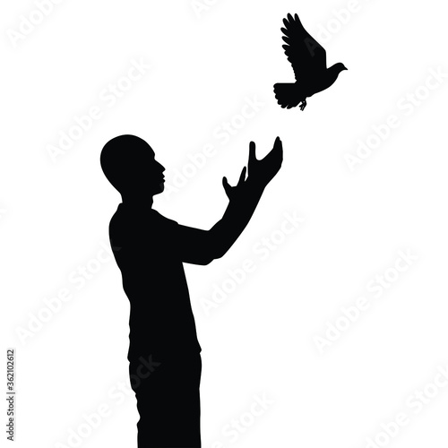 Young man releases a bird to freedom silhouette vector