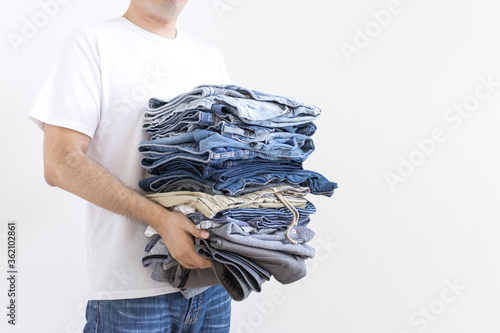 畳んだ衣類の洗濯物を運ぶ男性