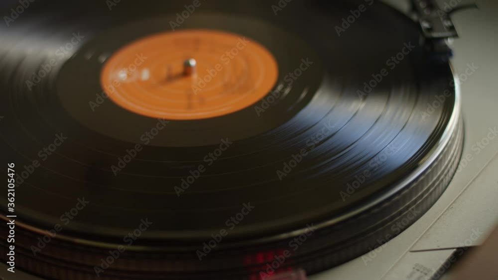 Close up of a vinyl record getting put on a turntable and starting to spin and play music Close up of a vinyl record getting put on a turntable and starting to spin and play music