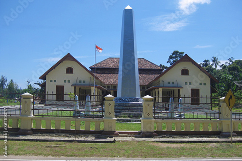 A monument stands in front of two building houses, historical relics of the Dutch colony in the Pacific Islands of Indonesia