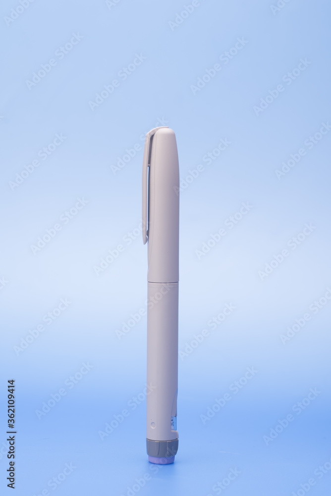 Insulin pen isolated over blue background Insulin pen isolated over blue background