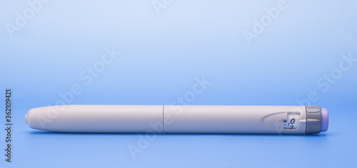Insulin pen isolated over blue background