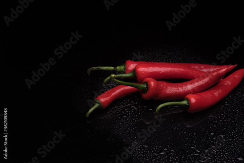 Heap of chili over dark reflective surface