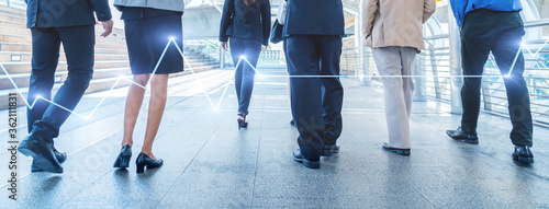 legs of business people walking in the modern city with Stock market or forex trading graph.