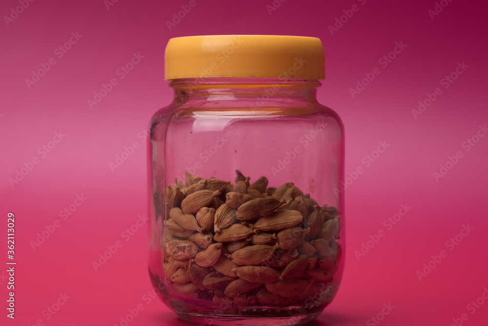 Cardamom herbs over red background Cardamom herbs over red background