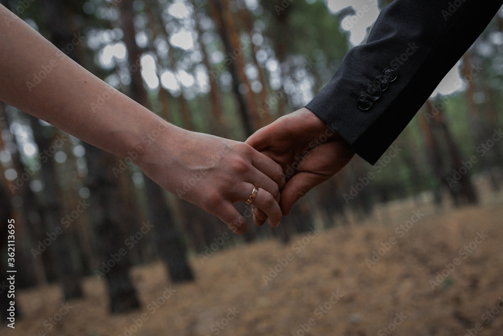 couple holding hands in wood