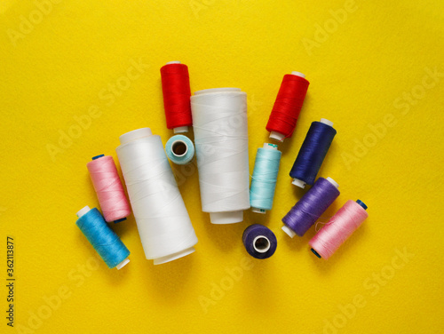 Multi-colored threads on a yellow felt background