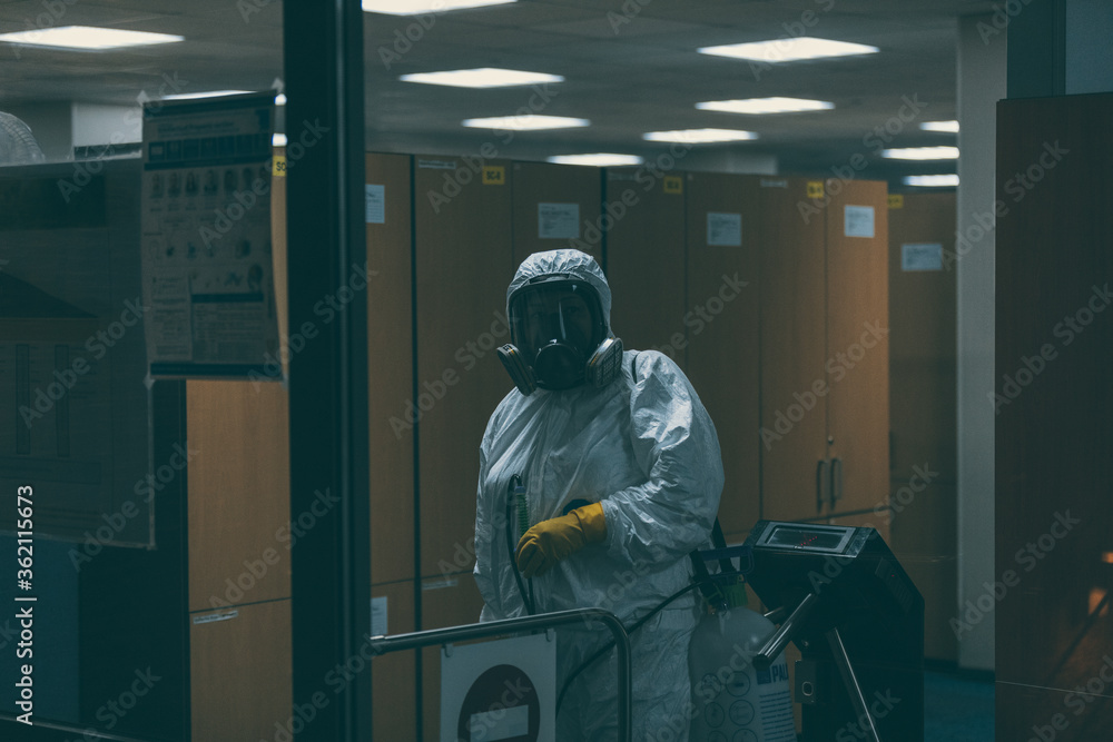 Disinfection in the office building. Human in HAZMAT white suit Disinfection in the office building. Human in HAZMAT white suit
