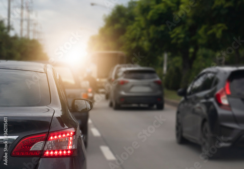 Luxury of car drive on the asphalt road. Traveling in the provinces during the bright period. open rear light signal. with trees beside the road.