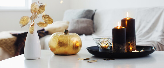 home decor with golden pumpkin and burning candles