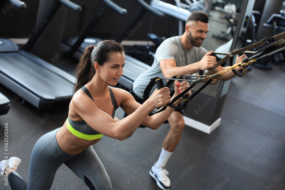 Obraz premium Young couple on body training with trx in gym.