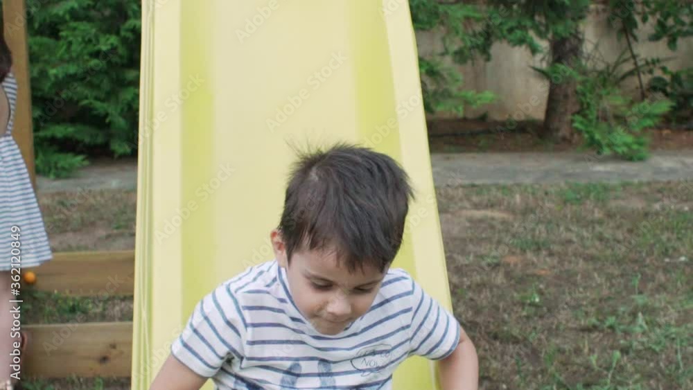 Caucasian toddler playing on a kid's slide outdoors slow motion Caucasian toddler playing on a kid's slide outdoors slow motion