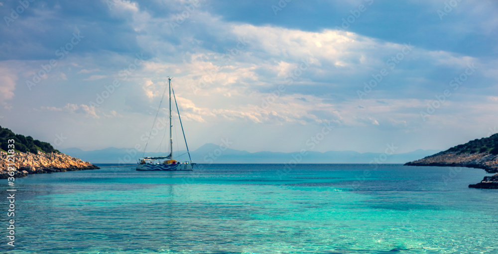 Fototapeta premium Sailing boat at distant remote island paradise with exotical vivid colors.