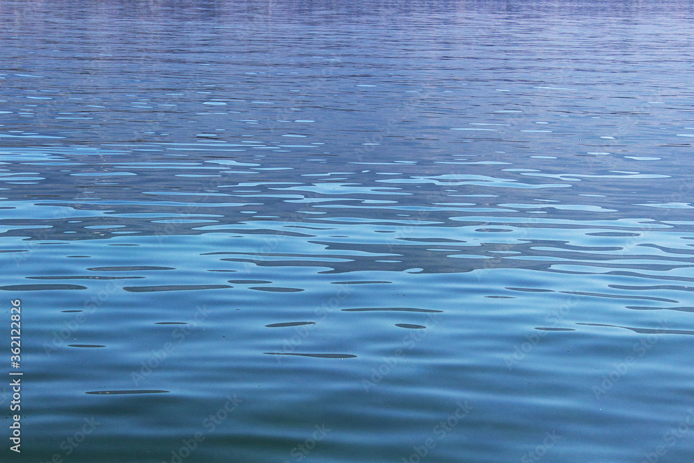 Naklejka premium Light blue wavy calm water surface background
