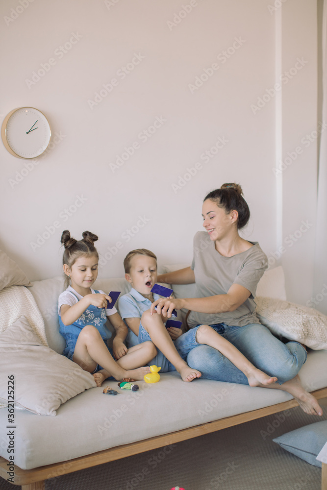 Mom playing with children at cozy playroom. Education, family and learning concept. Mom playing with children at cozy playroom. Education, family and learning concept.