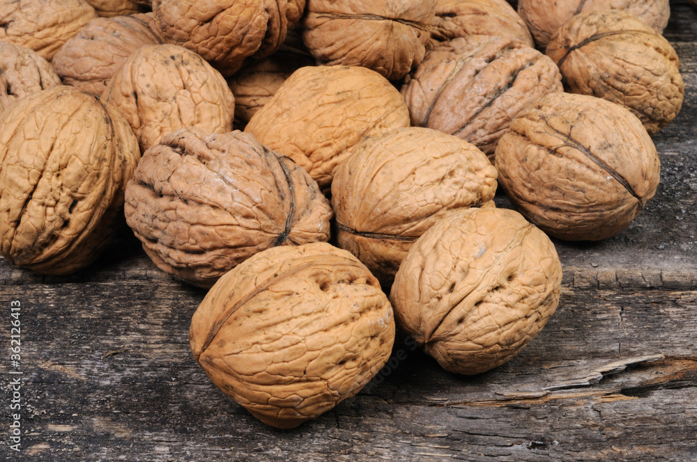 Walnuts are scattered on a wooden surface. Front view. Walnuts are scattered on a wooden surface. Front view.