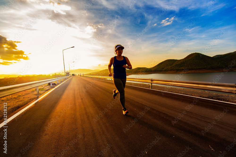 young fitness woman running in sunset
