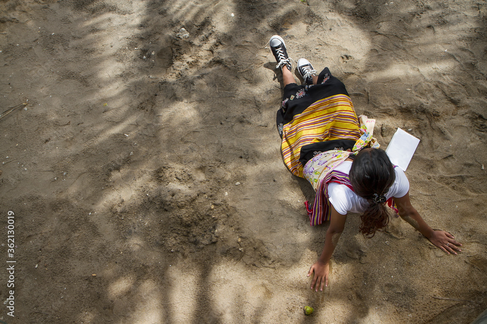 Obraz premium women wearing traditional ethnic fabric sitting on sand
