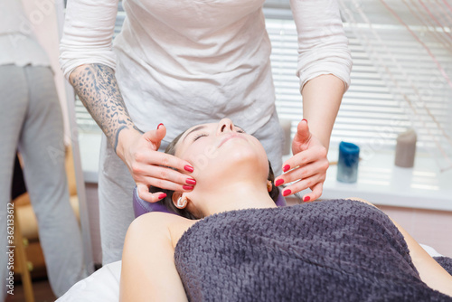 The master gives a facial massage to the client.