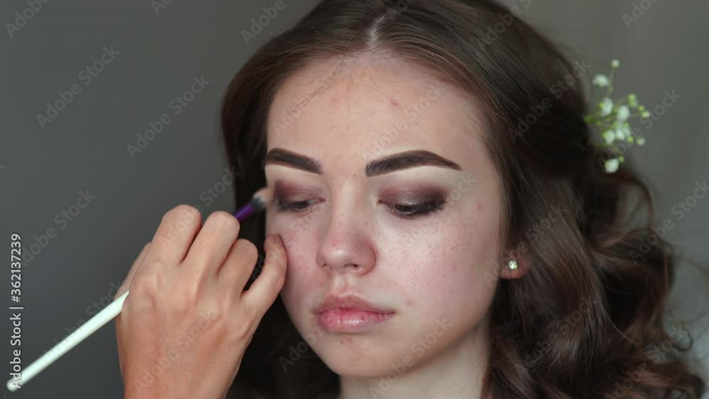 Makeup artist paints the eyelids of a girl model. Makeup artist paints the eyelids of a girl model.