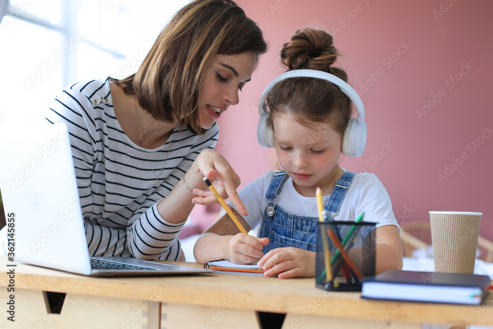 Mother and little daughter doing homework online. Distance learning online education. Mother and little daughter doing homework online. Distance learning online education.