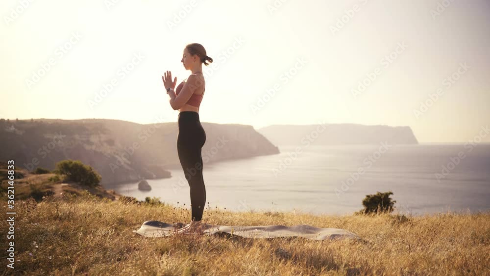 young woman doing yoga in the highlands near the sea young woman doing yoga in the highlands near the sea