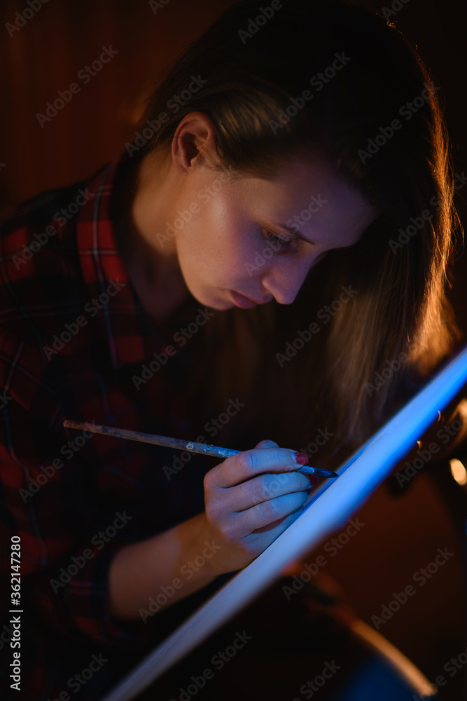 Obraz premium Close-up portrait of young beautiful woman with long hair who paints