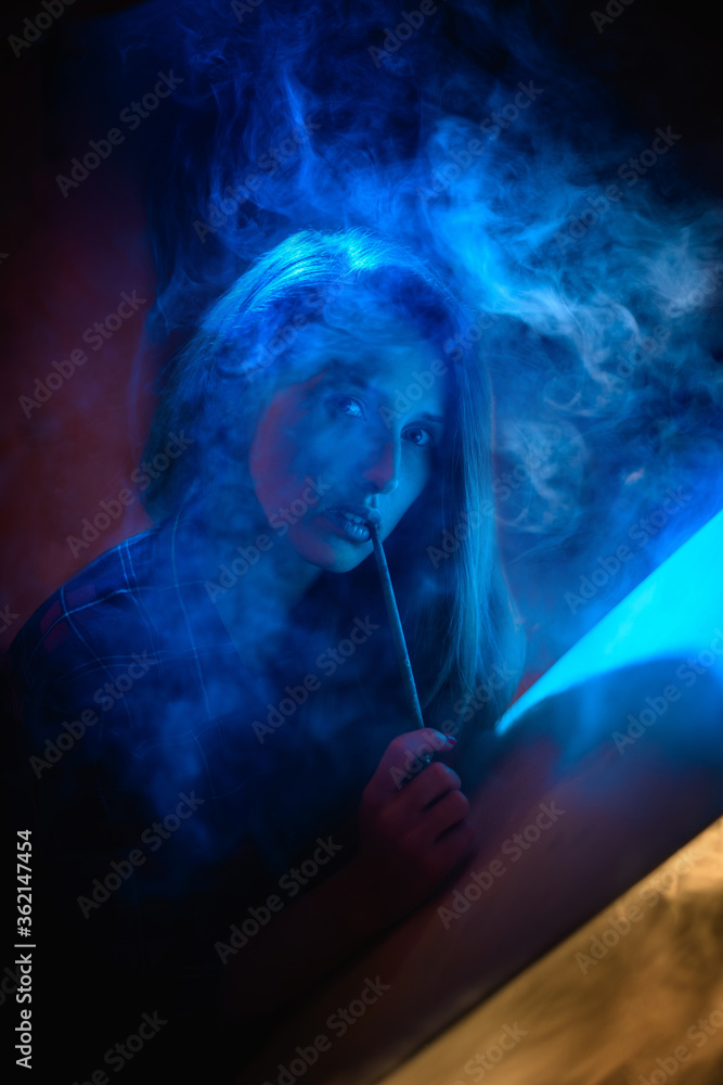 beautiful woman with brush and canvas in dark smoky room
