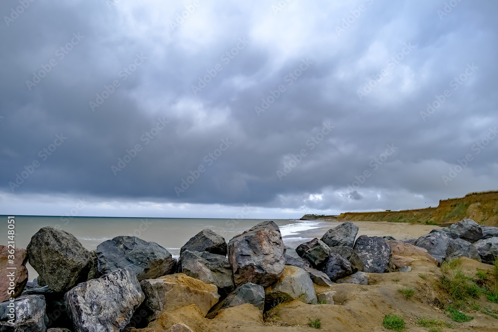 3 The rocky barrier protecting the sandy cliffs on a stormy day on Happisburgh beach, North Norfolk coast
