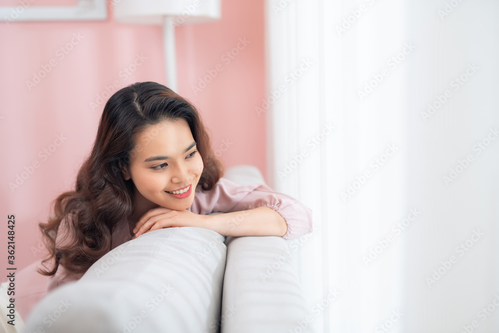 Beautiful young Asian woman relaxing on sofa. Beautiful young Asian woman relaxing on sofa.