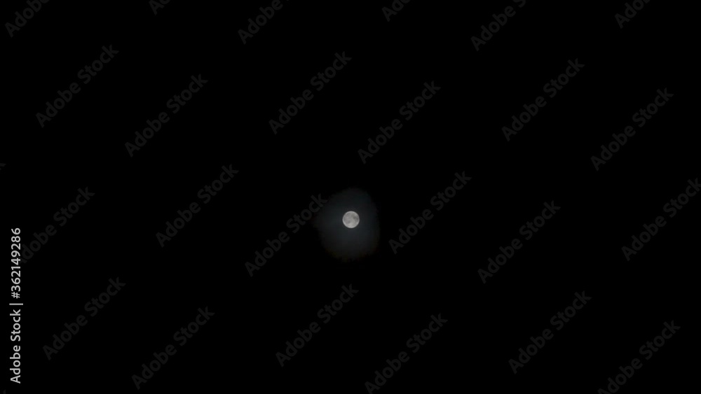 Moon and fast moving clouds against dark, black night sky-time lapse and reverse. Full moon Moon and fast moving clouds against dark, black night sky-time lapse and reverse. Full moon