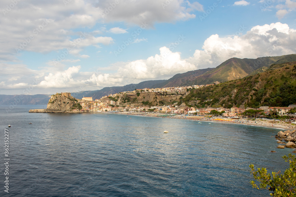 Costal road with village during a cloudy day. Italian village on a cliff in Calabria, Italy. The sea below it and a cloudy blue sky in background