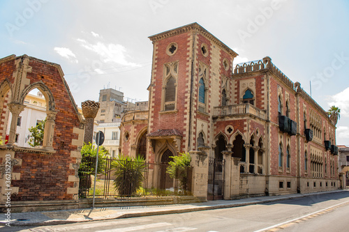 Fototapeta Naklejka Na Ścianę i Meble -  Old town of Reggio Calabria, Italy during a summer day. It is possible see villa genoese Zerbi, an historical building in red bricks in neo gothic style