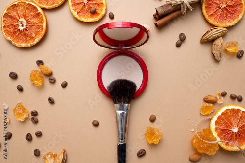 Cosmetics for natural makeup, powder, fluffy makeup brush on top.