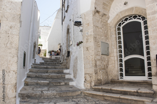 Old town of Ostuni during a sunny day, the white village. It is a turistic destination in Puglia ( apulia) in the summer. The city is in white stone bricks and is very old ( medieval time). © Giampaolo