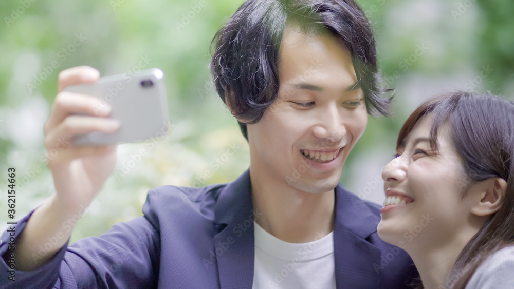 スマホのカメラで自撮りするカップル Stock Photo Adobe Stock