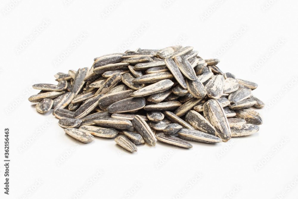 Salted and roasted sunflower seeds in shell isolated on white background Salted and roasted sunflower seeds in shell isolated on white background
