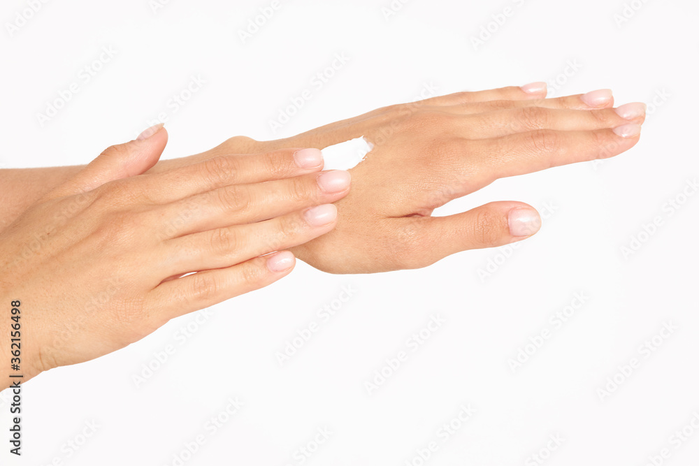 Female hands with cream. Close up of female hands applying cream on a white background