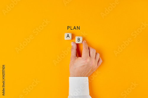 Hand of a businessman choosing business plan b out of two options photo
