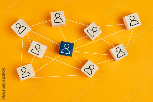 Wooden blocks with people icon on yellow background. Organization structure, social network, leadership, team building, recruitment, management or human resources concepts.