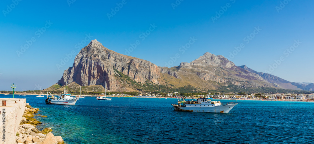 A view of harbour traffic at San Vito lo Capo, Sicily with impressive mountain backdrop in summer