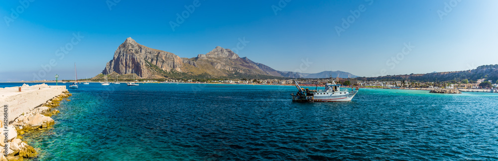 A panorama across the harbour entrance of San Vito lo Capo, Sicily with impressive mountain backdrop in summer