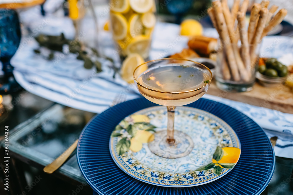 A coupe of champagne on table at a terrace in the evening. Concept of an open air party. A coupe of champagne on table at a terrace in the evening. Concept of an open air party.