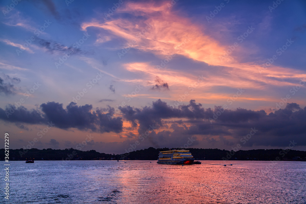 Small cruise boat with beautiful sunset at Goa, India. - obrazy, fototapety, plakaty 