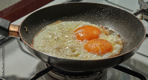 Adding  black pepper to the simple fried eggs    