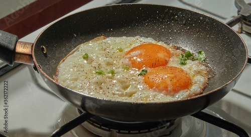 Adding coriander to the simple fried eggs    
