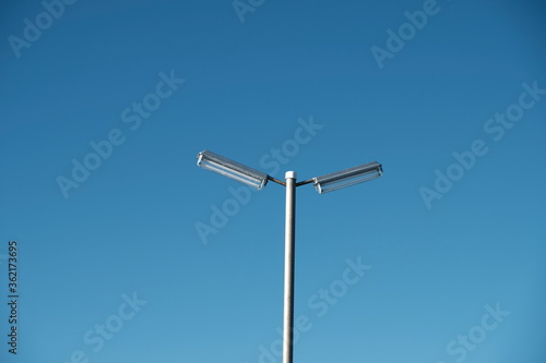 Electric pole on the beach on blue sky background.