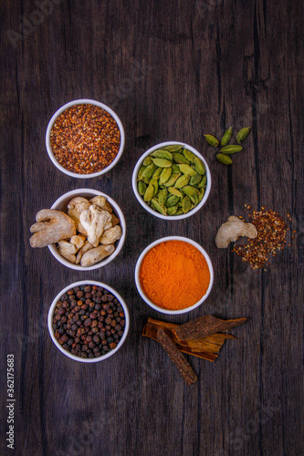 Different types of spices in small dishes with different colors together from the top view.